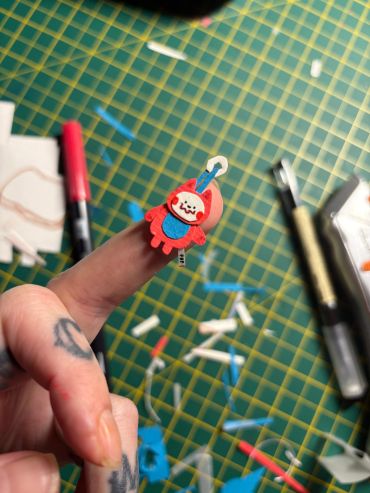 A finger puppet resembling a red and blue cartoon character.