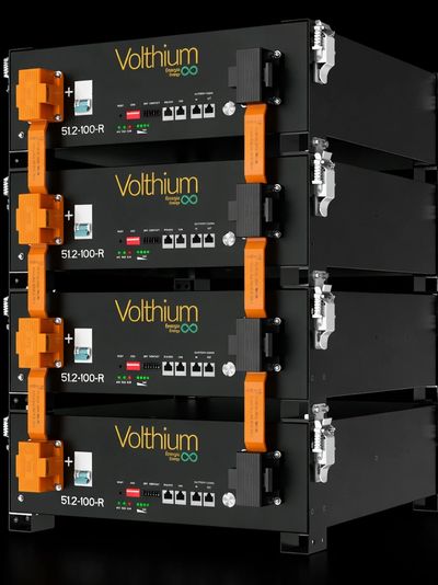 Stacked Volthium energy storage units with orange connectors and network ports.