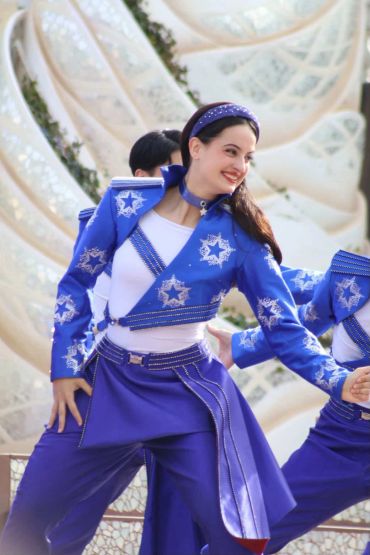 Dancer in vibrant blue costume performing.