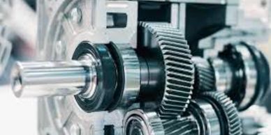 Close-up of metal gears and shafts in a mechanical gearbox.