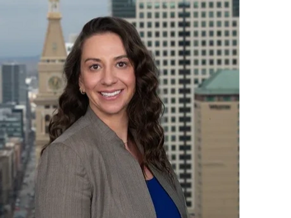 Professional woman smiling with cityscape background.