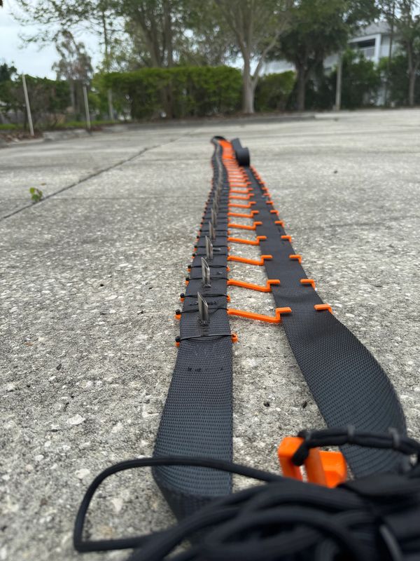 Black and orange zigzag strap laid out on concrete.