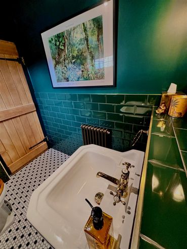 Burlington basin tap with green metro wall tiles black and white mosaic floor tiles 