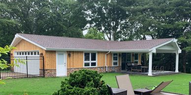 wood and stone pool house with fence trees and grass