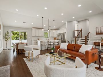 Modern open-concept living room and kitchen with elegant furniture and ample natural light.