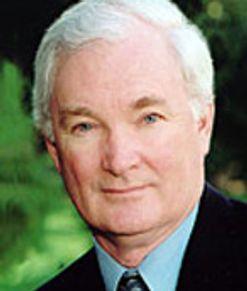 Portrait of an elderly man with white hair in a suit.