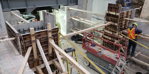 A construction worker doing work in a press pit for heavy machinery. 