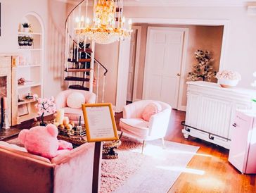A cozy living room with pink furniture and warm lighting.