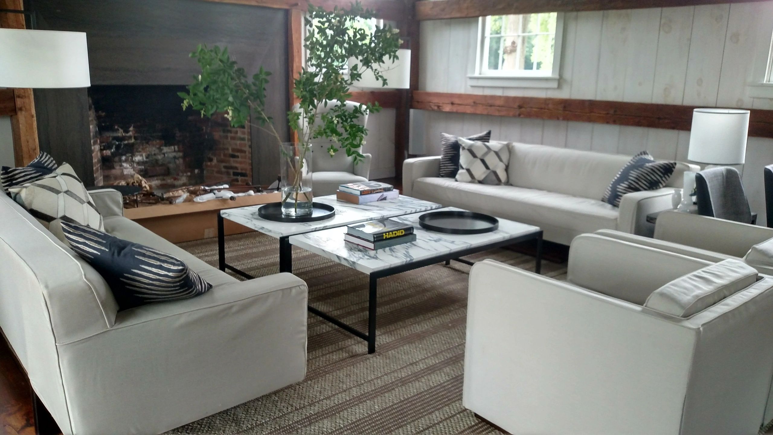 Cozy living room with white sofas and plants.
