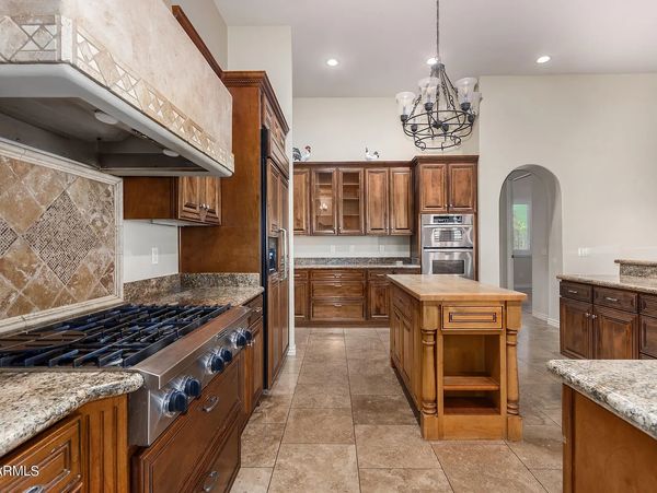 Spacious kitchen with wooden cabinets, granite countertops, and a central island.