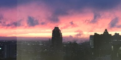 Cityscape through a window during a vibrant sunset