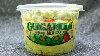 Container of traditional Mexican-style guacamole with avocado and tomato graphics.