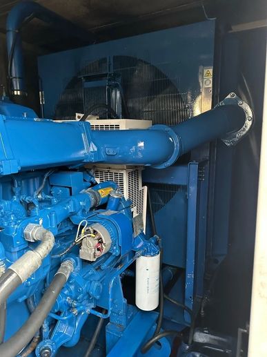 Blue industrial engine or generator setup inside a compartment.