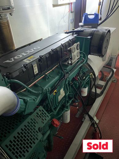 A Volvo engine in a workshop with a 'Sold' sign.