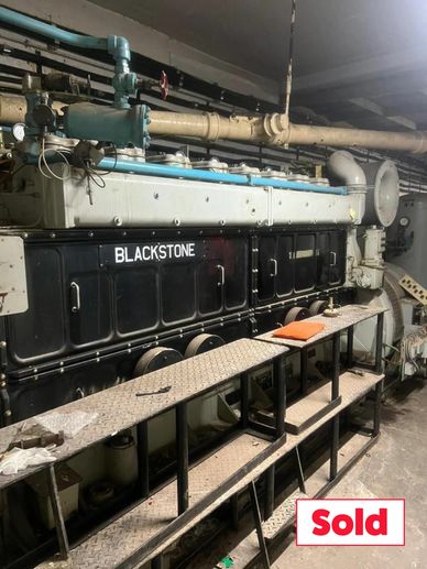 Large industrial Blackstone engine with a 'Sold' sign in an indoor setting.