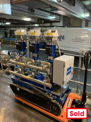 Industrial pump system on a mobile platform in a warehouse setting.