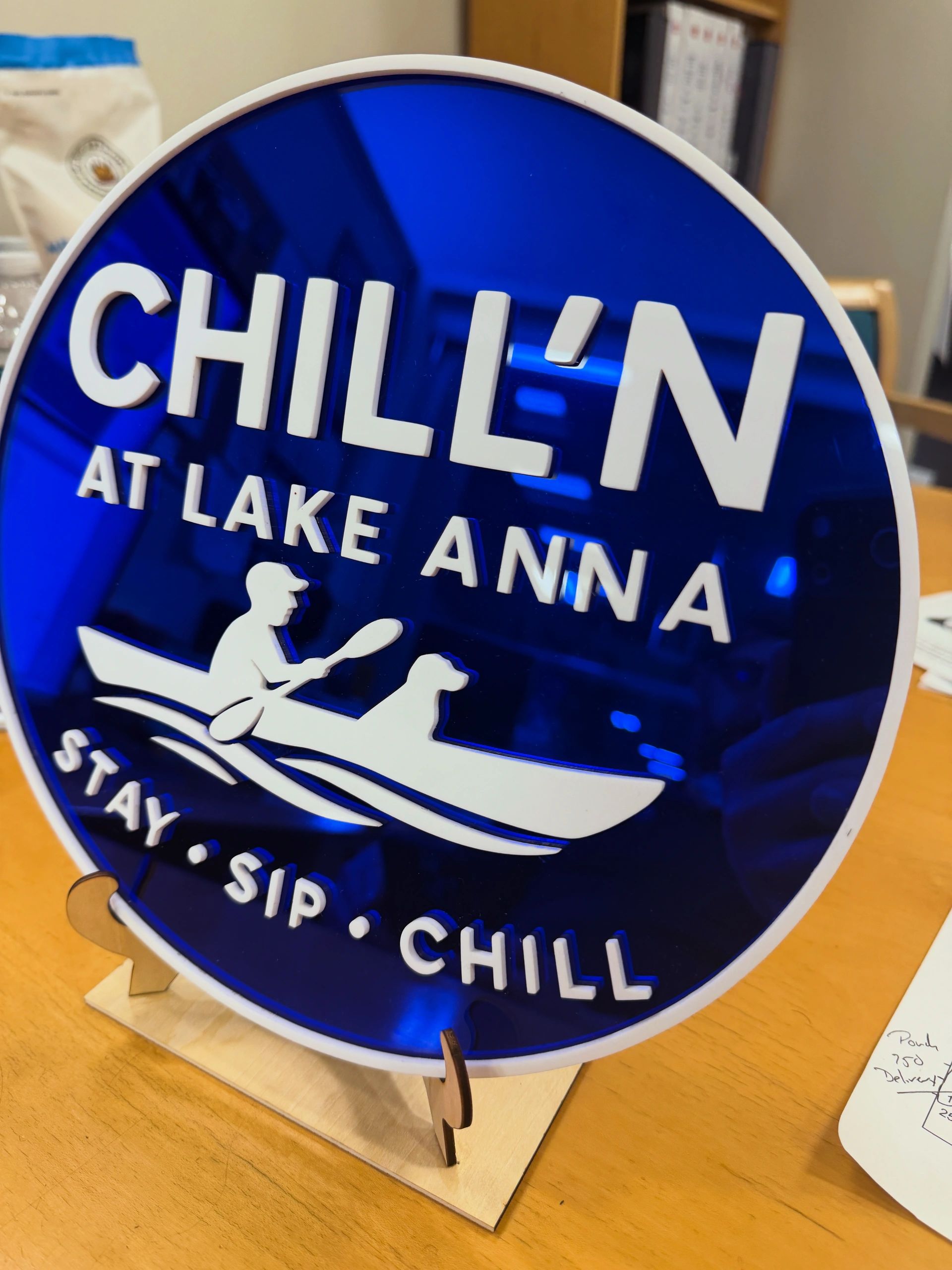 A blue sign reads "CHILL'N AT LAKE ANNA" with a person and dog in a boat.