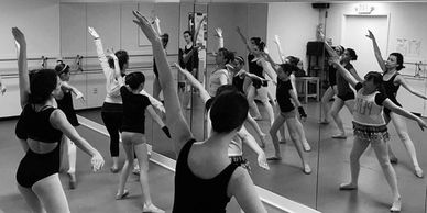 Black and white photo of ballet dancers rehearsing in a studio.