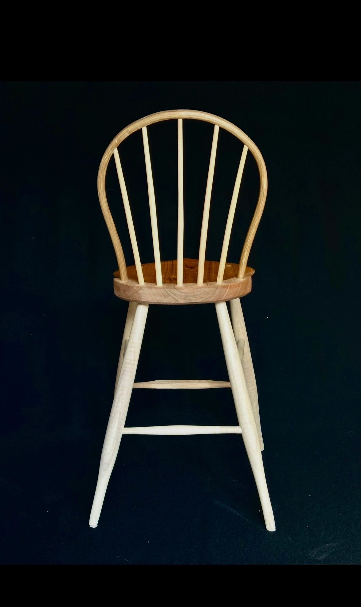 Chaise en bois avec dossier arrondi et barreaux.