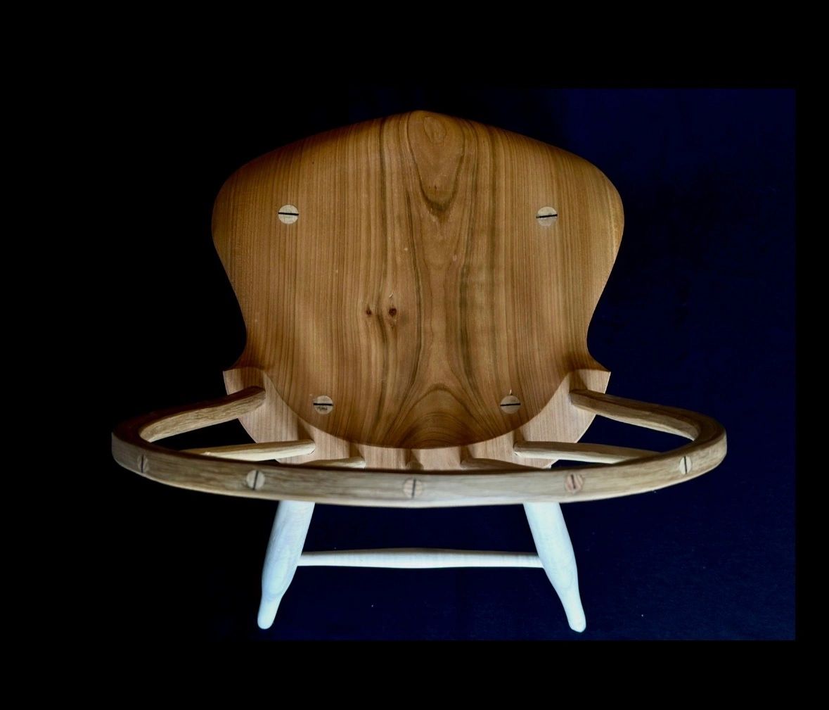 Chaise en bois design vue de dessus sur fond noir.