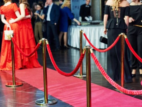 a woman in red gown walking on red carpet 