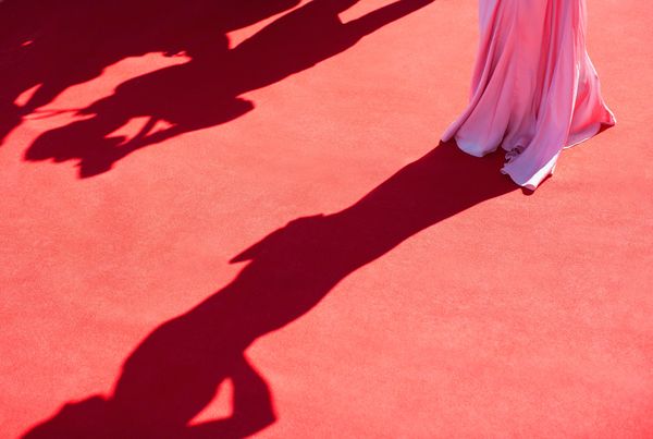 a woman walking on a red carpet in pink gown 