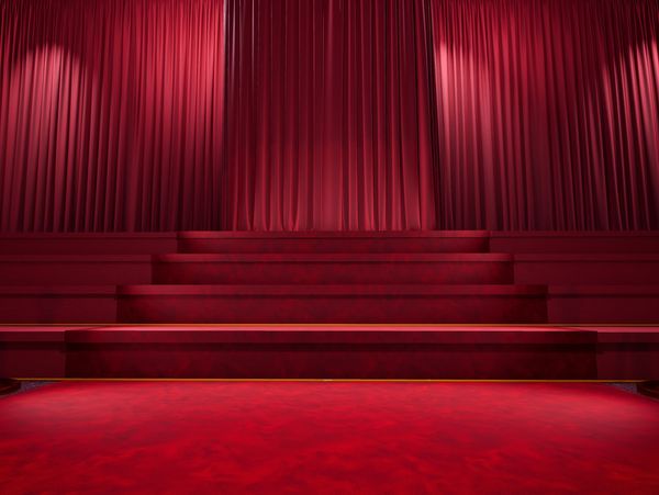 a stage with red curtains and carpet 
