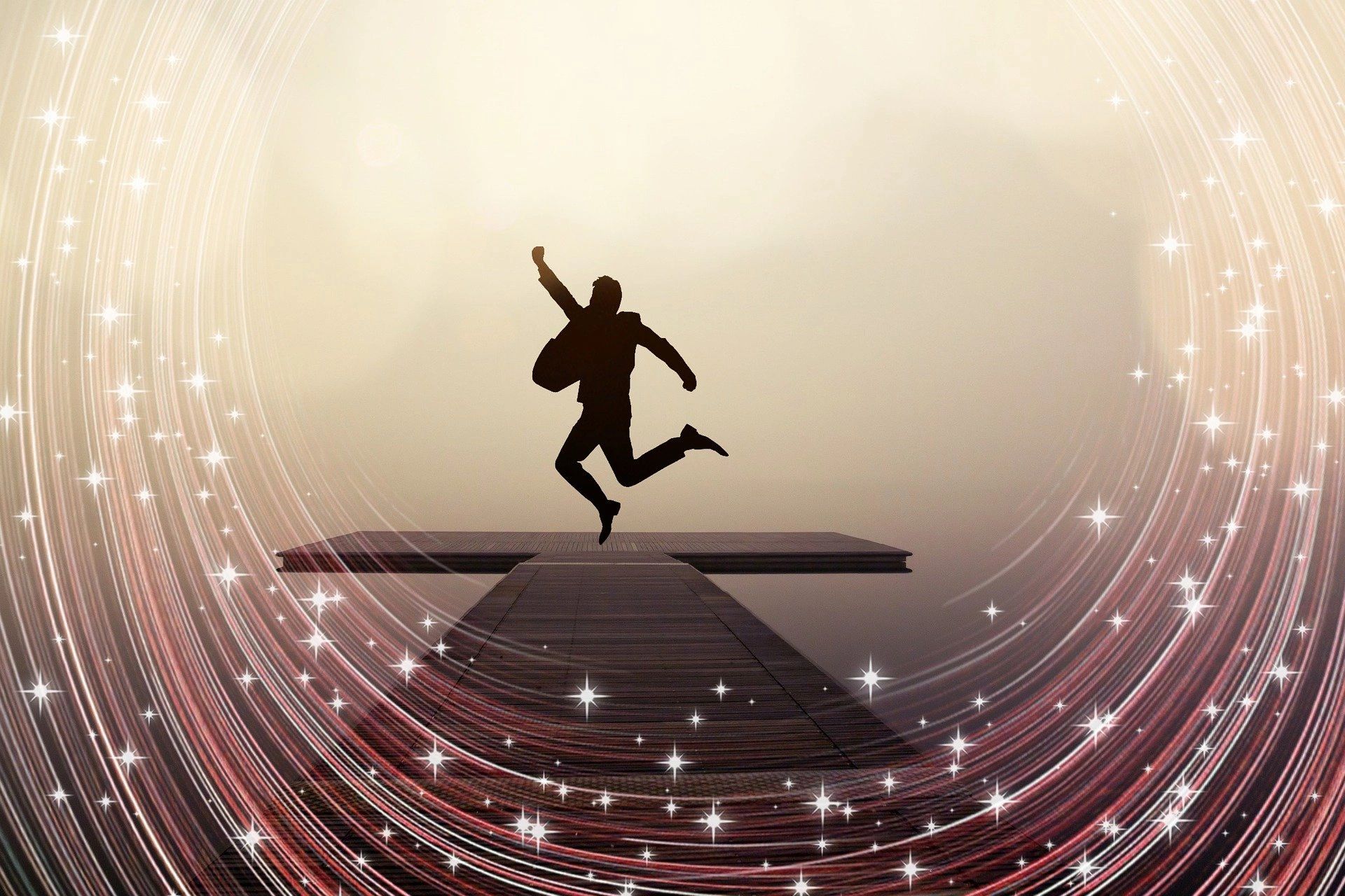 Silhouette of a person joyfully jumping with magical sparkles surrounding.