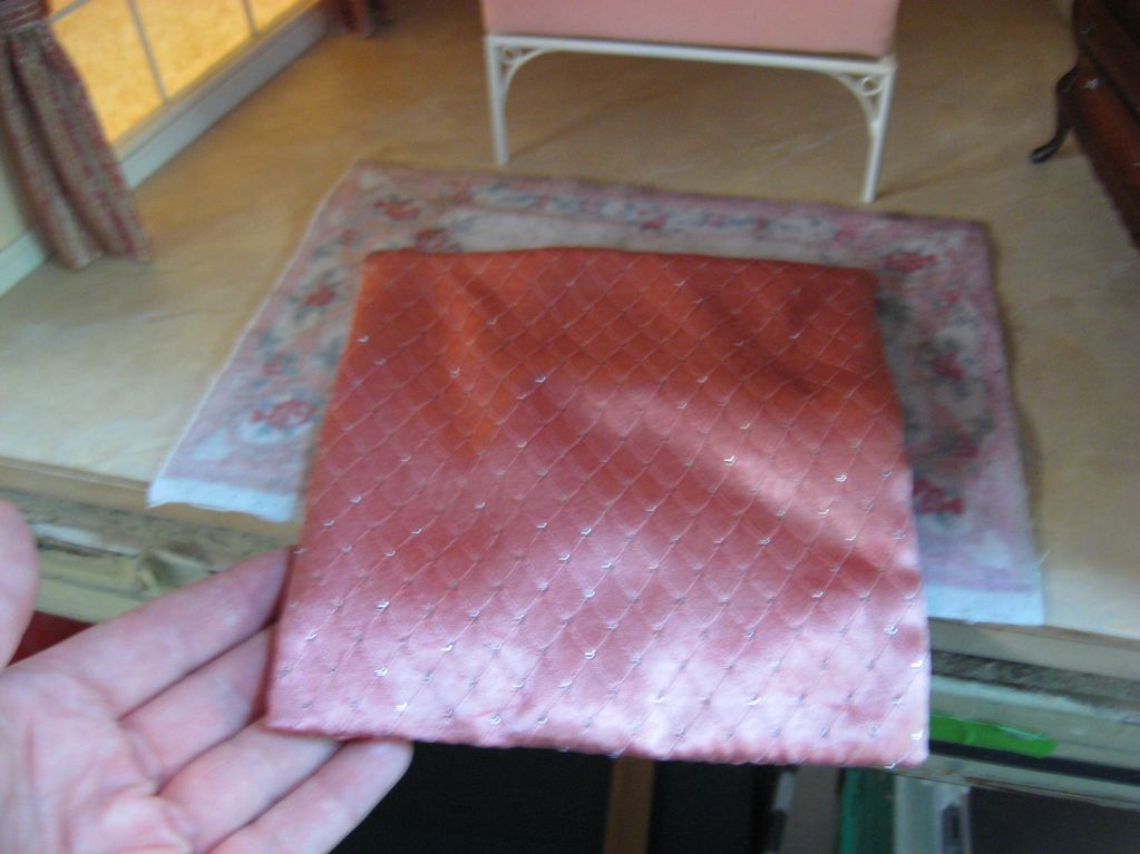 Image is a miniature bedroom set, a miniature quilt in the center of the photo.