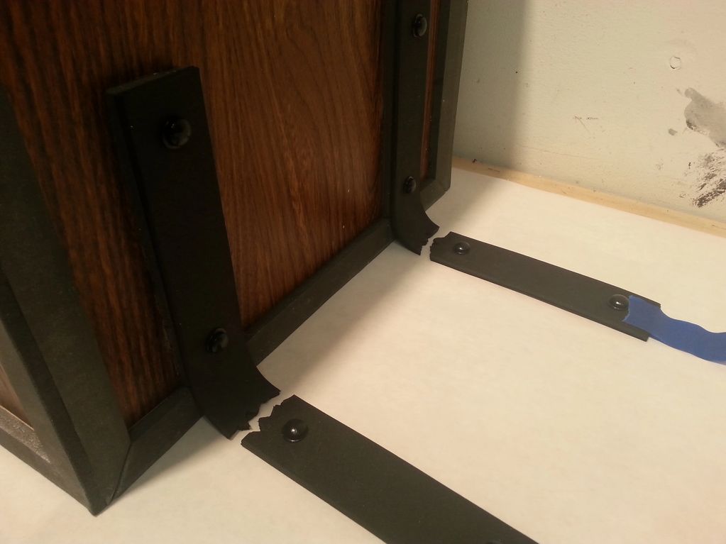 Side view of the wood grain box, with black straps, which are shown separated