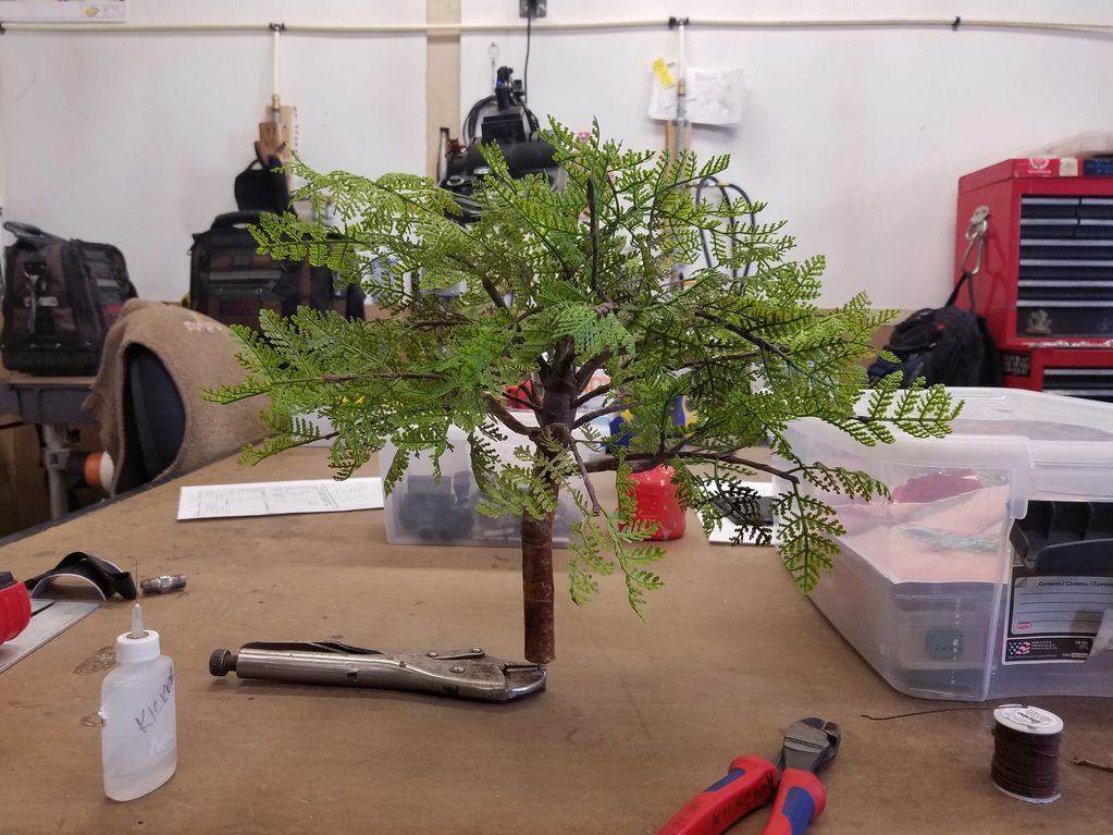 Image of a tree being built. The bench is strewn with tools and supplies.