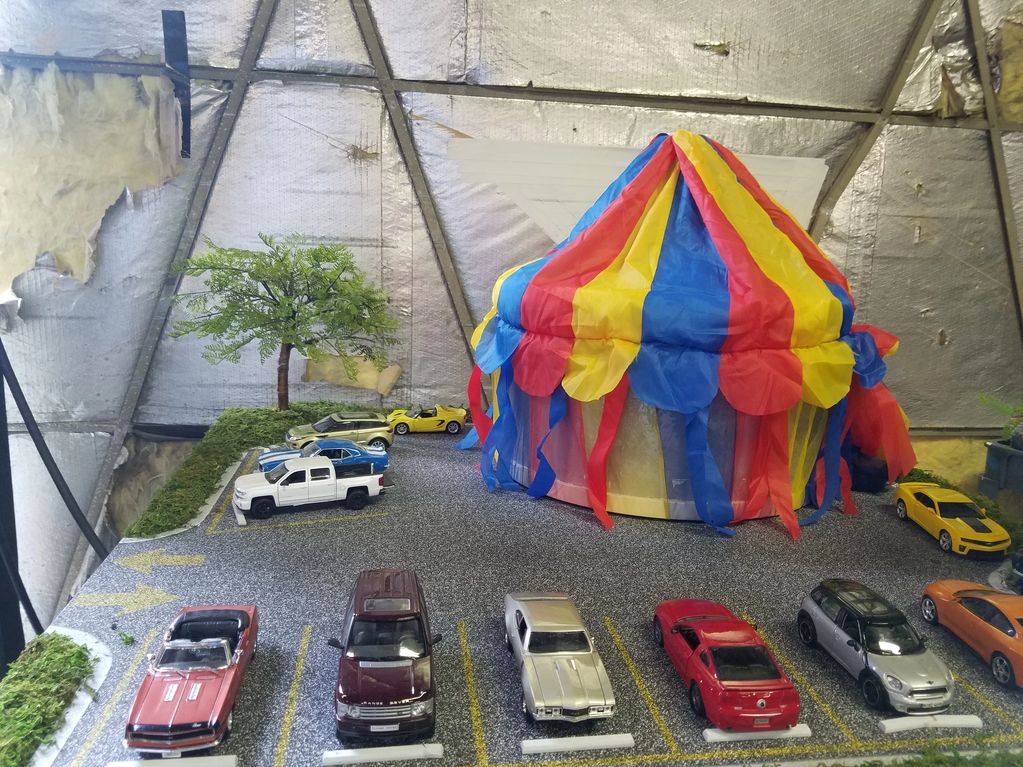 Image of circus tent model with cars and landscaping.