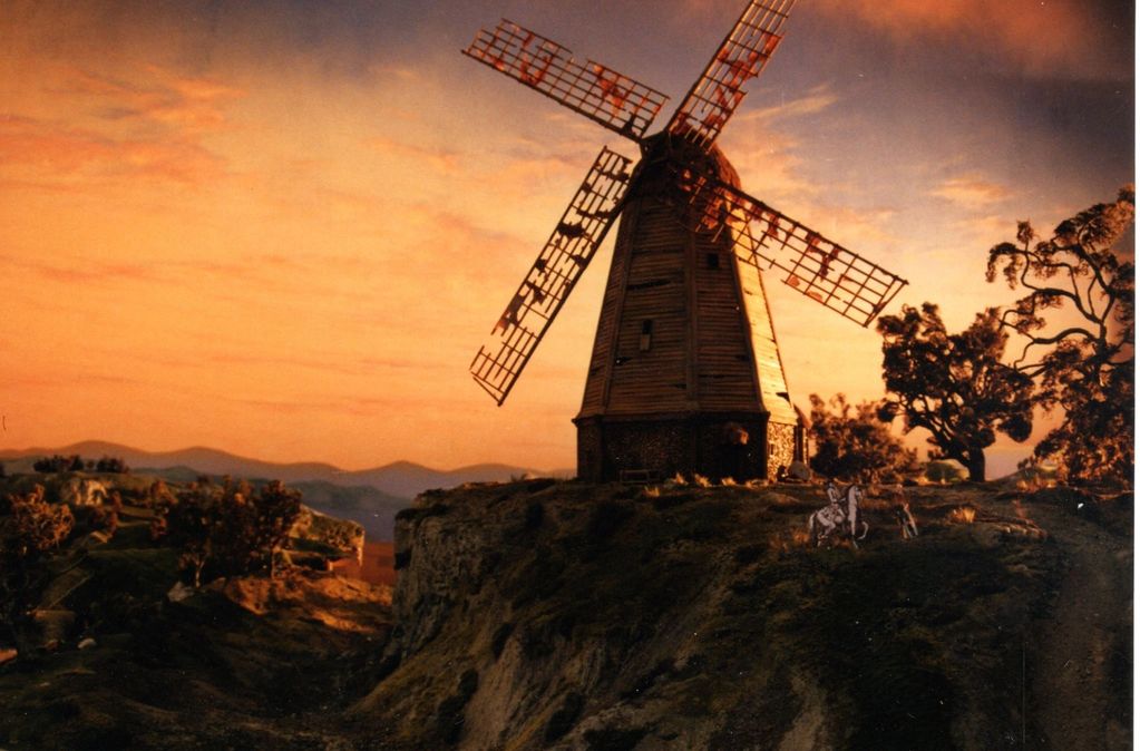 Image shows a miniature windmill set with a canyon to the left and some trees in the foreground.  It