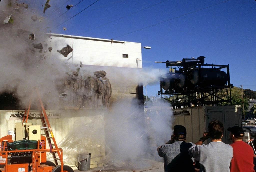 Image of pyro test in motion, showing tree and cliff face exploding.