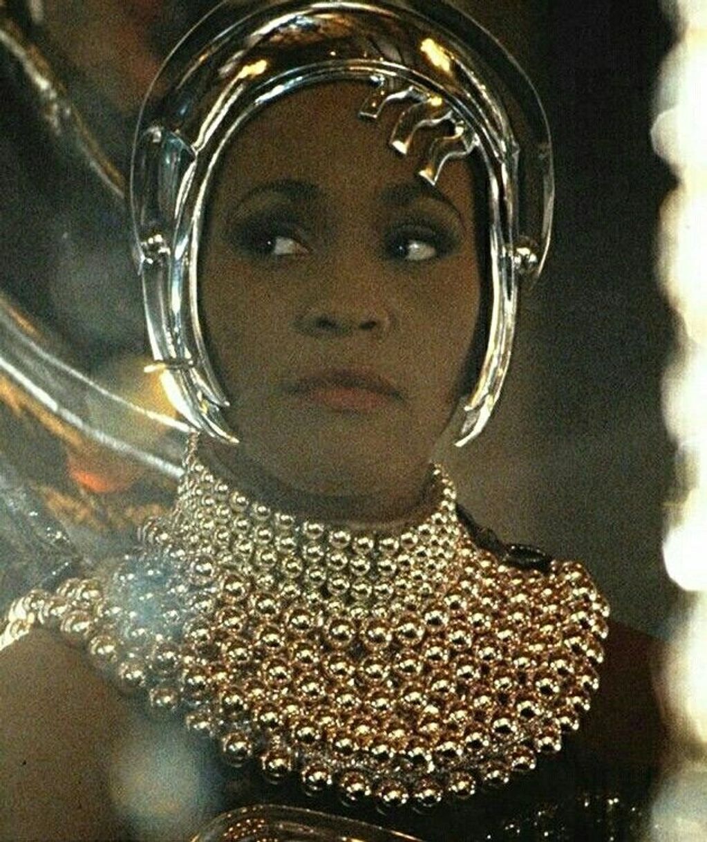 Image is a closeup of Whitney Houston in an early version of the helmet for the Queen of the Night.