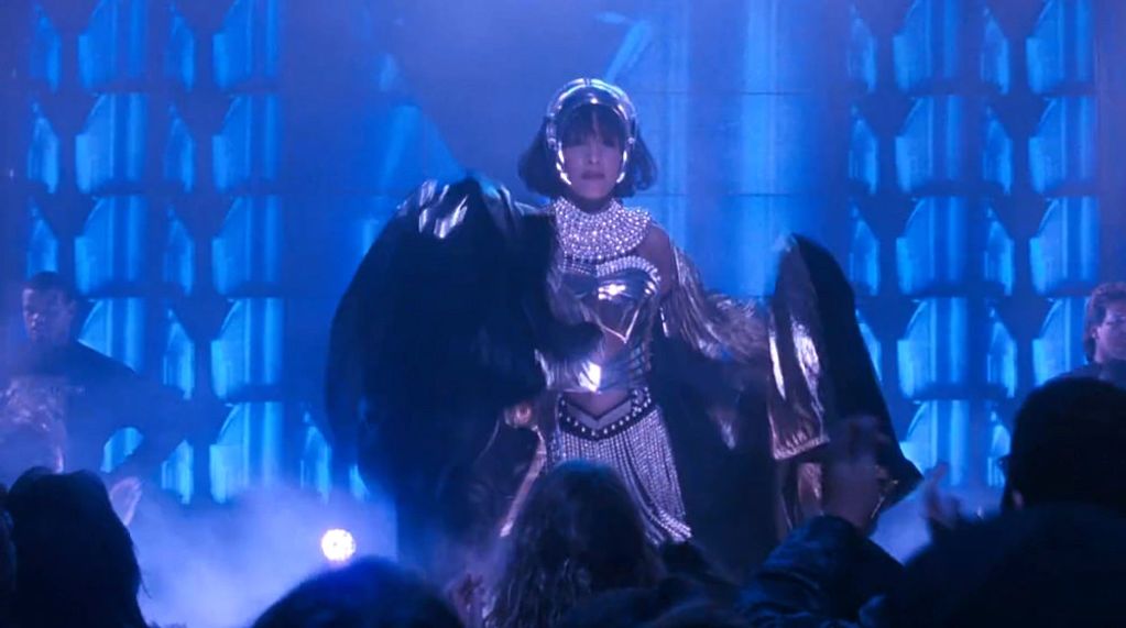 Image shows Ms. Houston removing the cape at the club.