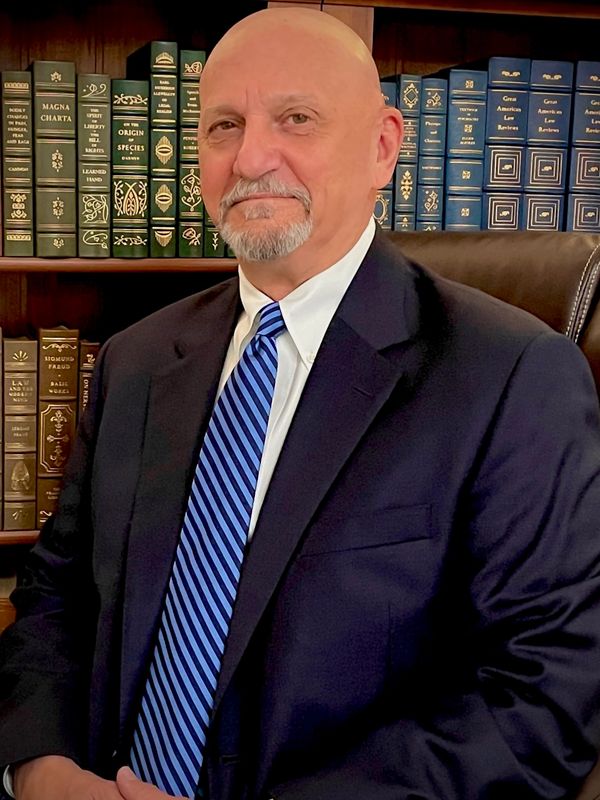 Professional Photo of Jeffrey Siegel PhD, Forensic & Clinical Psychologist sitting in front of books