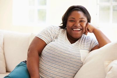 black chubby lady smiling on couch