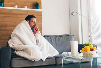 sick man coughing on couch