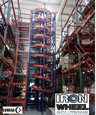 Tall industrial spiral conveyor system in warehouse aisles.
