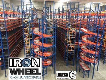 Large warehouse shelving system with orange conveyor wheels and blue frames.
