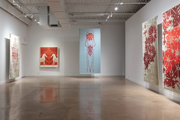 Modern art gallery with large red and white abstract paintings on white walls.