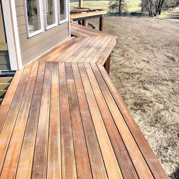 Newly built wooden deck extending from a house into a yard.
