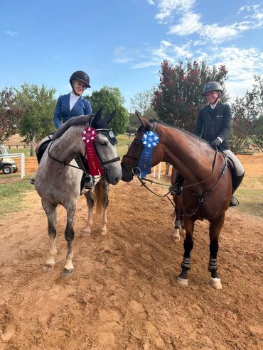 Two riders with horses and ribbons.