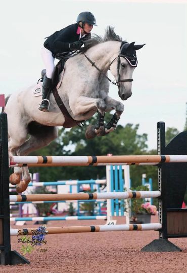 Equestrian jumping over a fence.