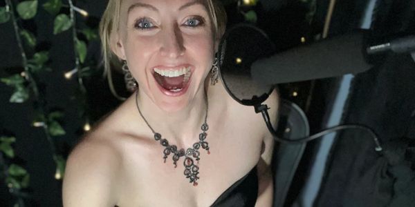 Happy woman singing into a microphone.