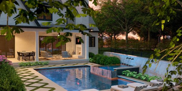 Custom swimming pool with spill over edge spa design by H2Outdoor Living.