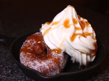Two Apple Cider Donuts from Dude's Donuts baked in the oven topped with vanilla custard and caramel 
