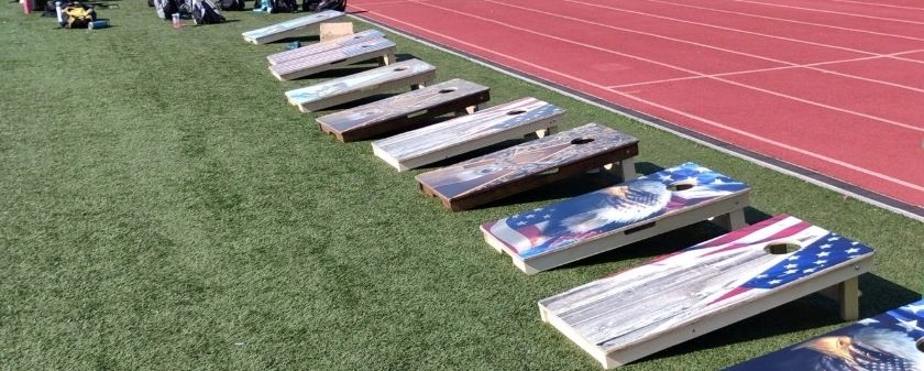 Stack of books next to pencils in a holder and a camera.