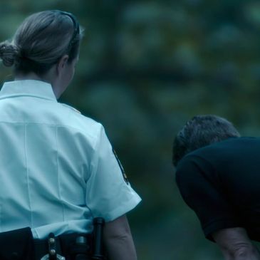 A police officer and a man interacting outdoors.